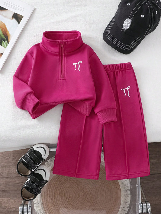 Prenda fucsia conjunto de dos piezas para bebe vista frontal con lazos bordados