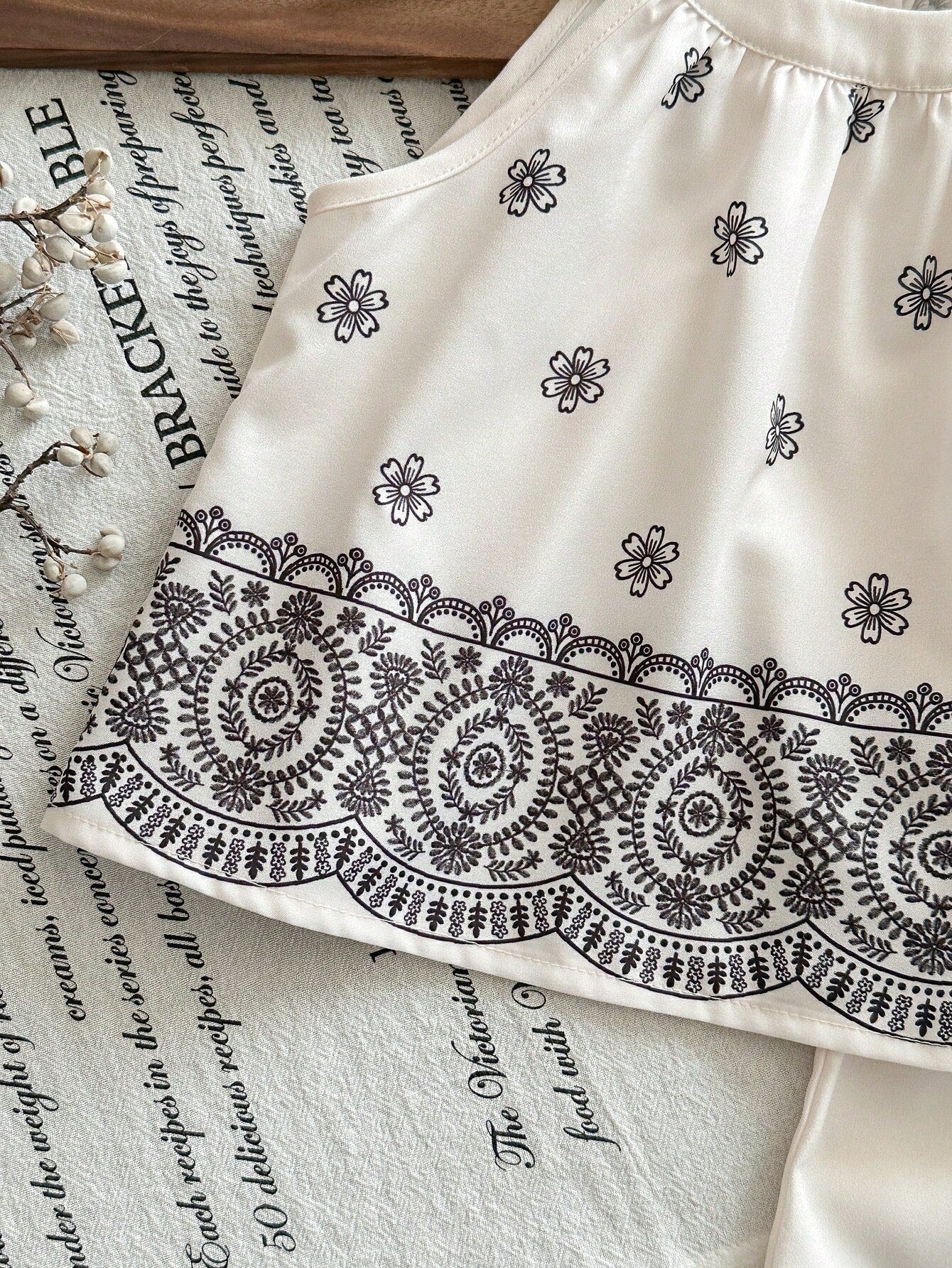 Prenda blanca conjunto para bebe con estampado floral negro detalle del acabado