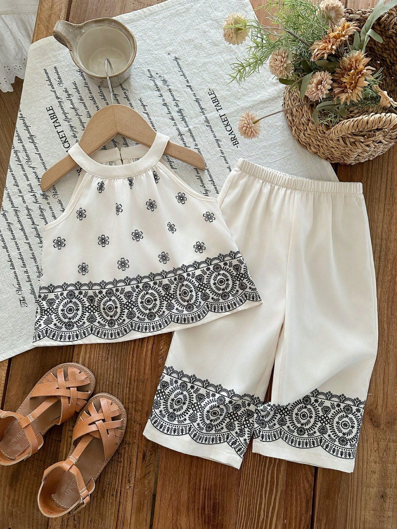 Prenda blanca conjunto para bebe con estampado floral negro vista frontal