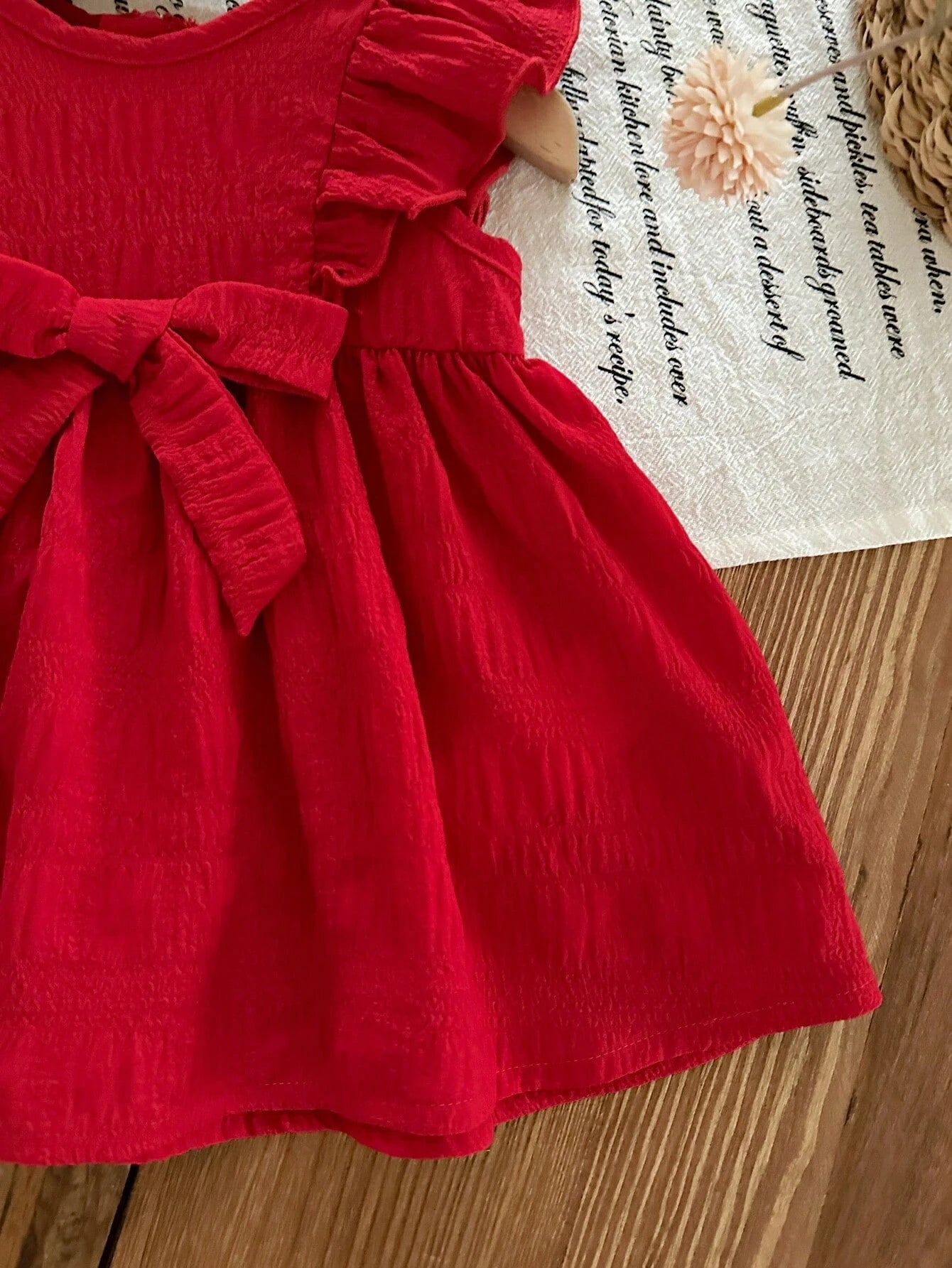Prenda rojo vestido para bebe con detalle de volantes en hombros
