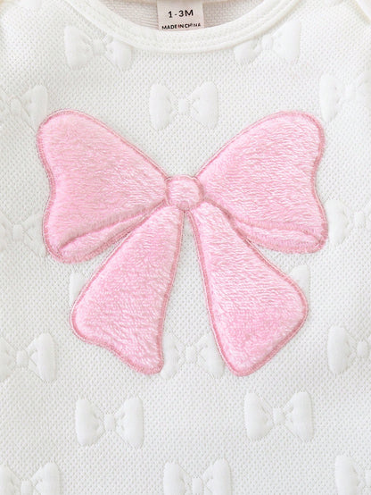 Prenda blanco mameluco para bebe detalle de lazo rosado en relieve
