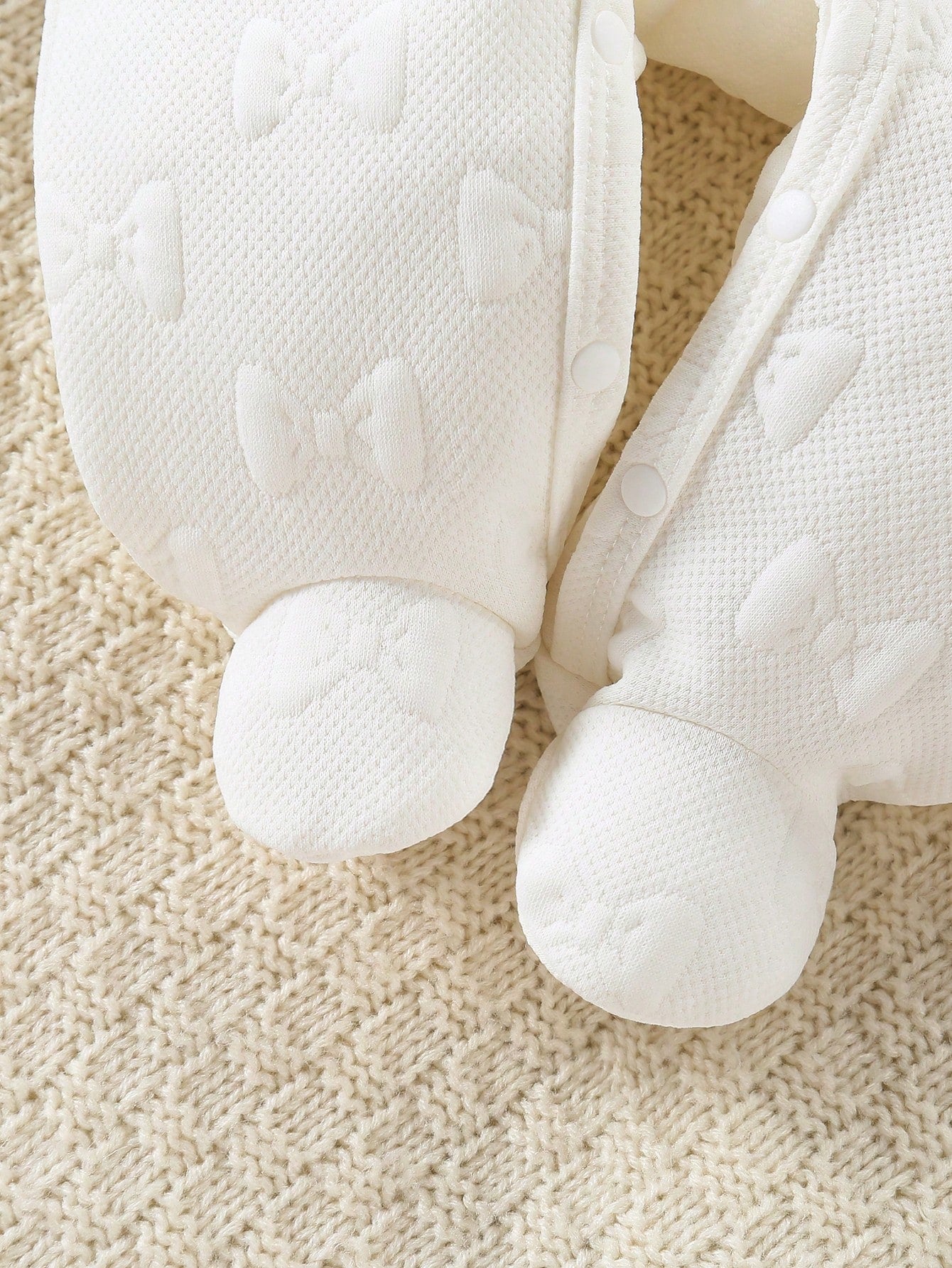 Prenda blanco mameluco para bebe detalle de broches y textura