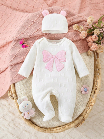 Prenda blanco mameluco para bebe con lazo rosa y gorro vista frontal
