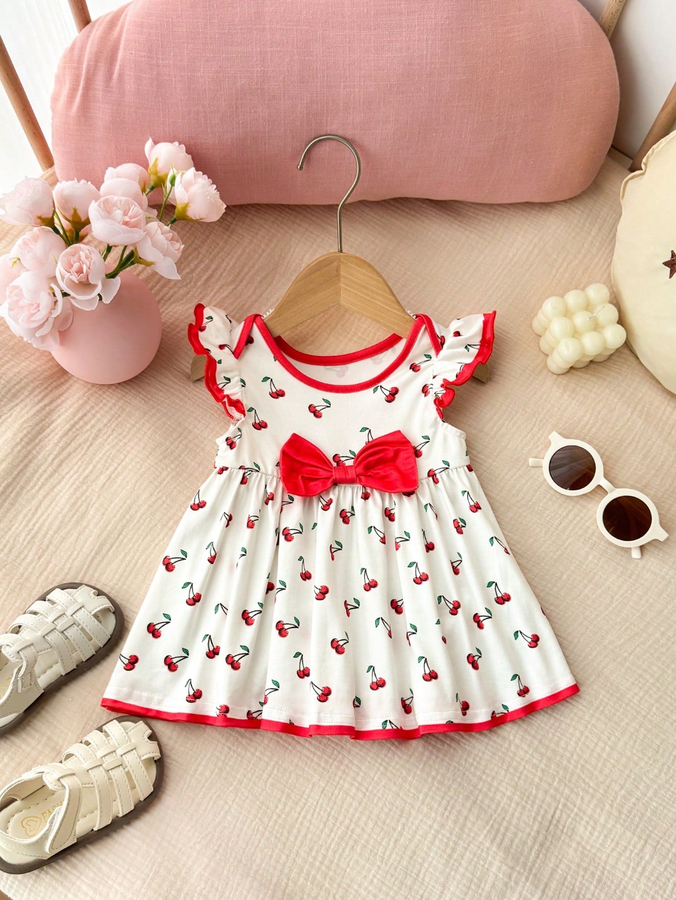 Prenda blanco vestido para bebe con estampado de cerezas y lazo rojo vista frontal
