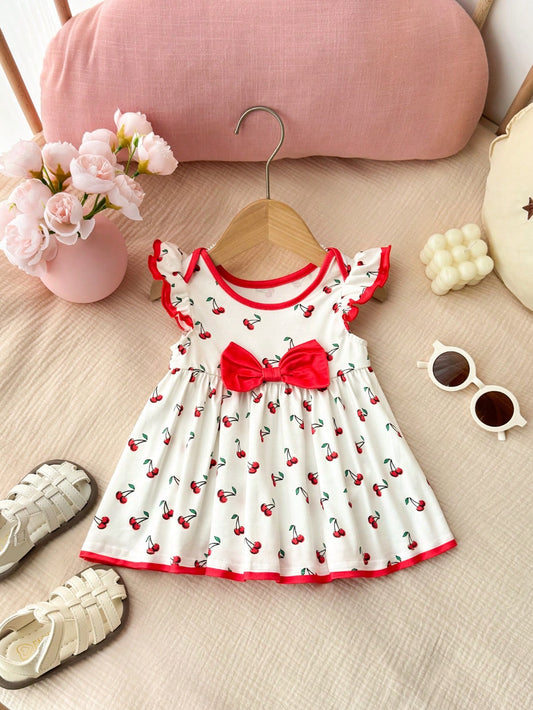 Prenda blanco vestido para bebe con estampado de cerezas y lazo rojo vista frontal
