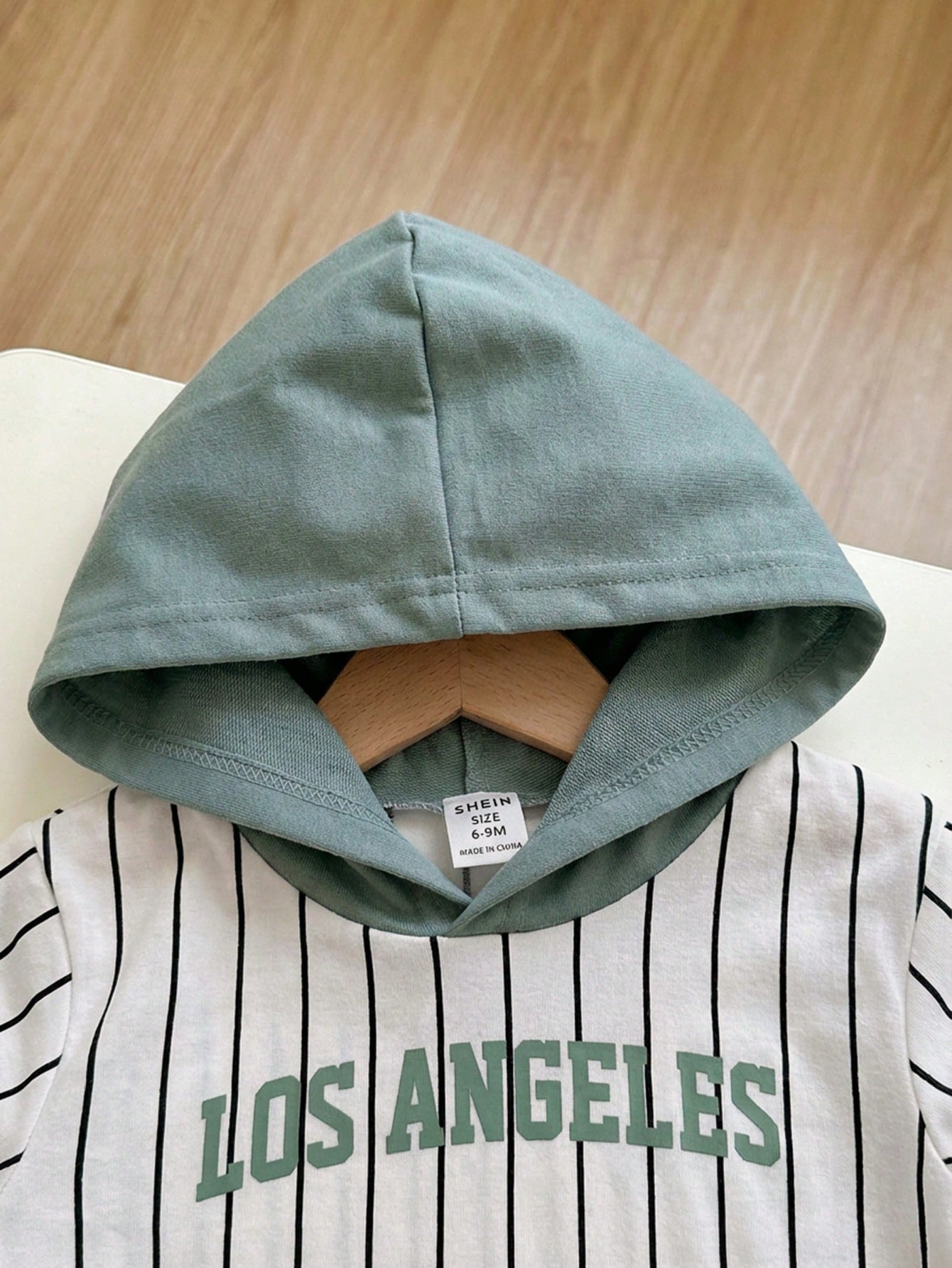 Prenda verde conjunto para bebe con detalle de capucha
