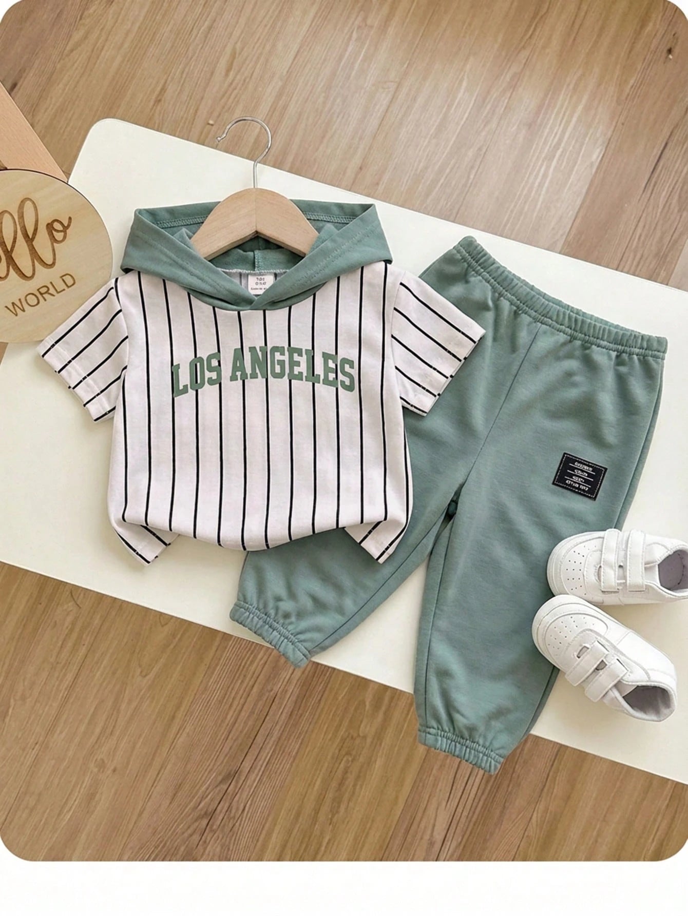 Prenda verde conjunto para bebe con capucha y rayas vista frontal
