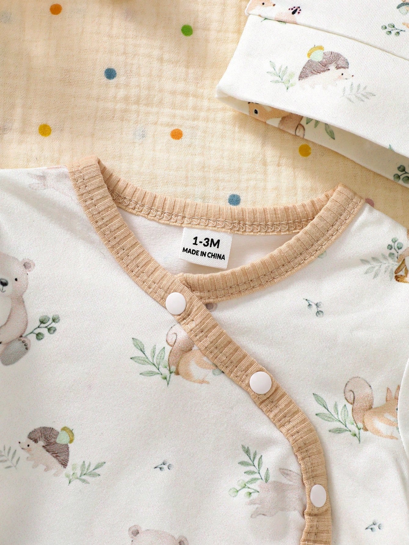 Prenda beige conjunto para bebe con botones frontales detalle
