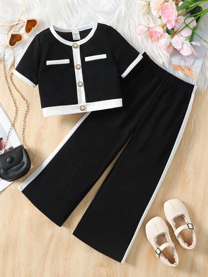 Prenda negro conjunto elegante para bebe vista frontal con camiseta bicolor y pantalón amplio
