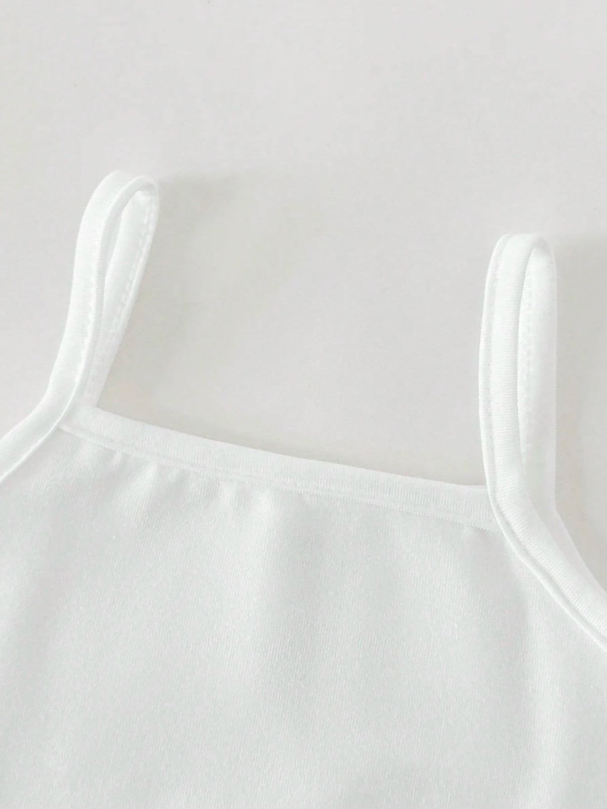 Prenda blanca camisola para bebe con tirantes finos detalle frontal