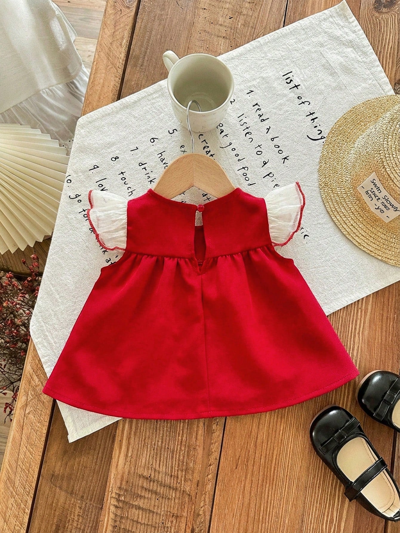 Prenda roja vestido para bebe con volantes de tul y botones vista trasera
