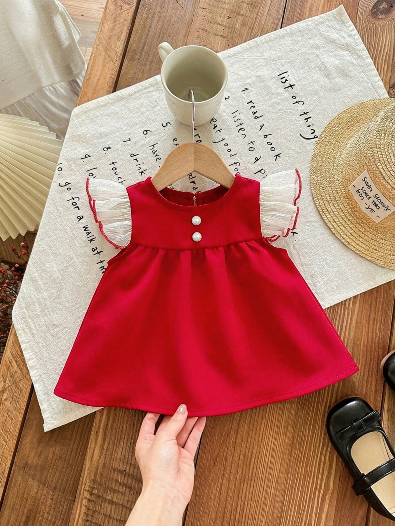 Prenda roja vestido para bebe con volantes de tul y botones vista frontal
