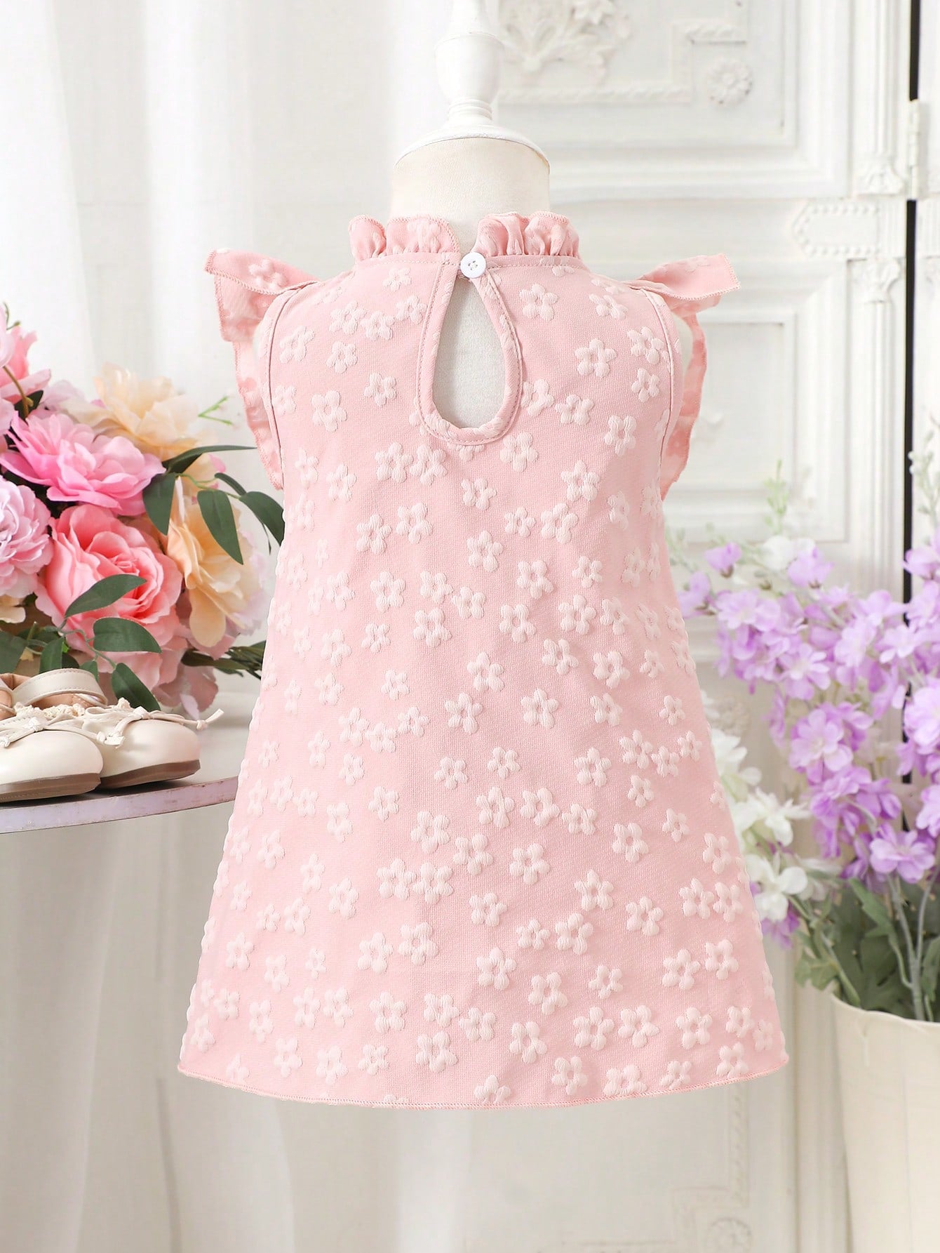 Prenda rosa vestido para bebe con lazo y flores texturizadas vista trasera
