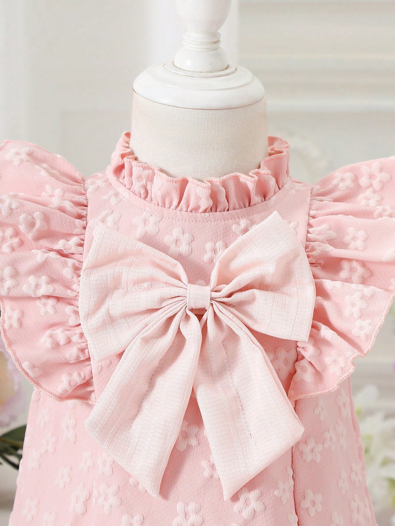 Prenda rosa vestido para bebe con detalle de lazo frontal
