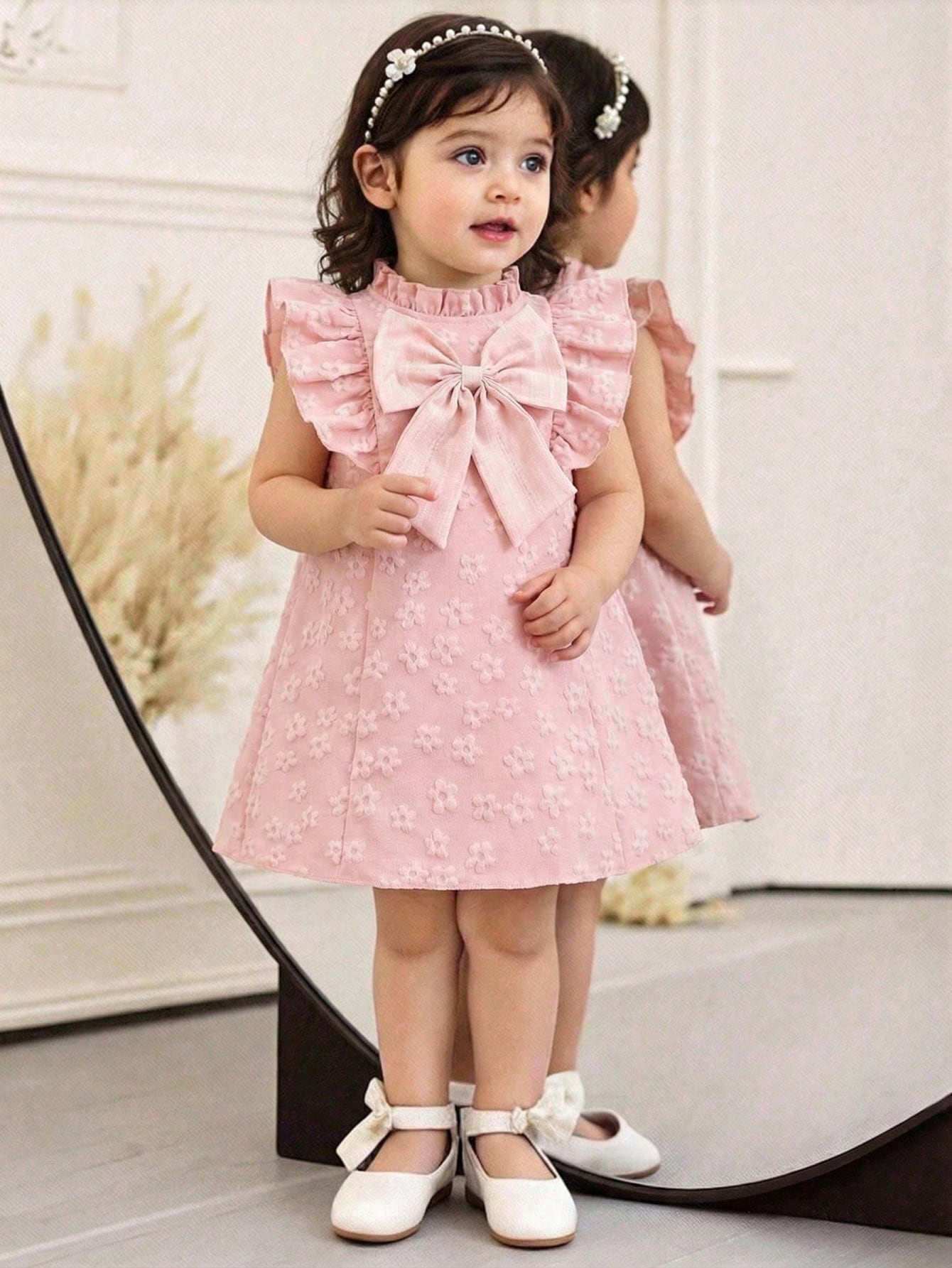 Prenda rosa vestido para bebe con lazo y flores texturizadas vista frontal
