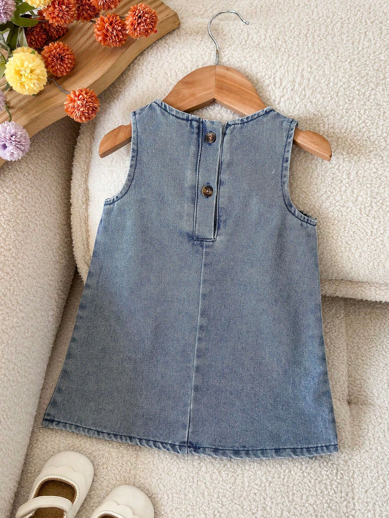Prenda azul vestido de mezclilla para bebe con botones traseros vista posterior
