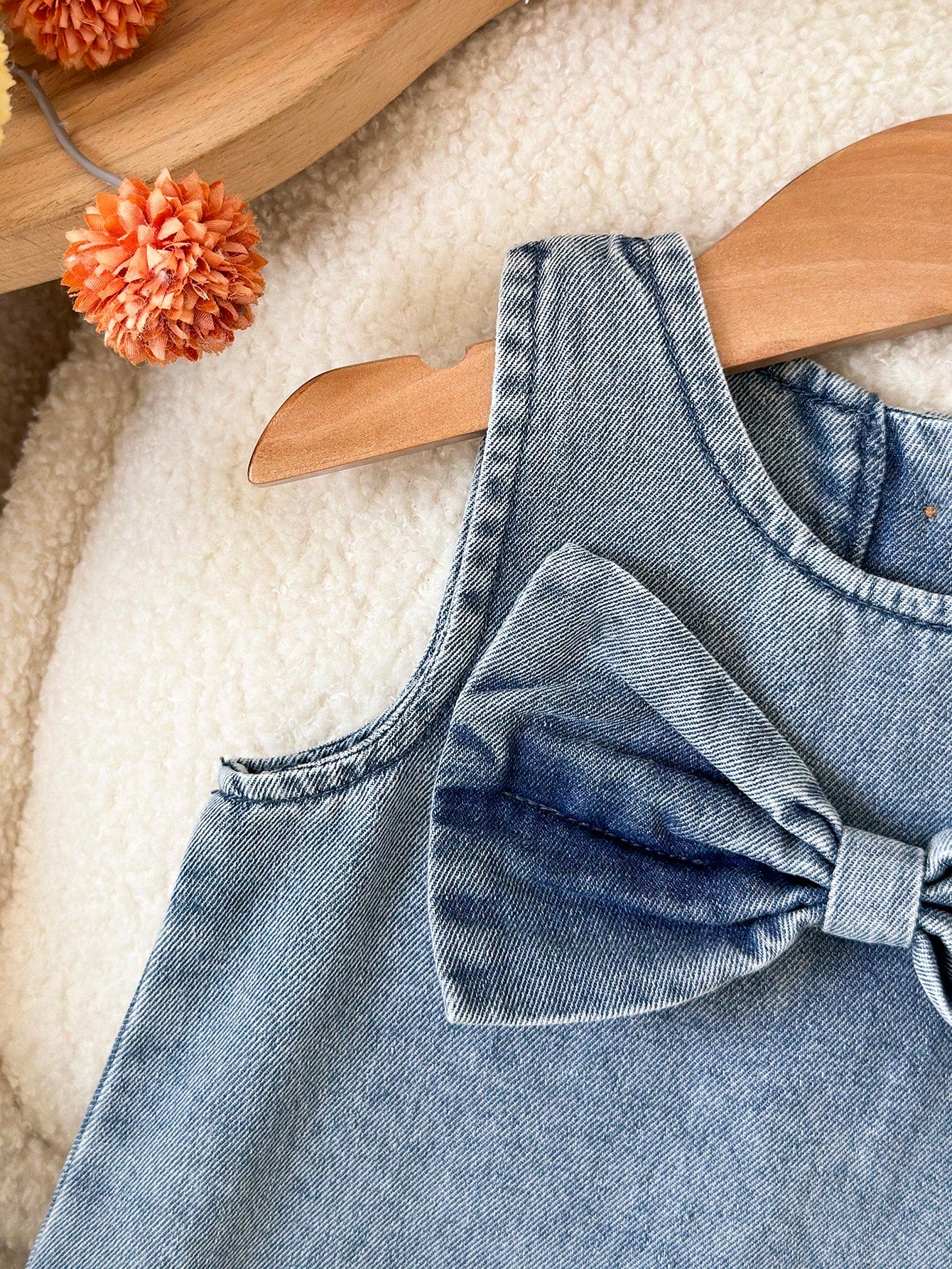 Prenda azul vestido de mezclilla para bebe detalle de lazo frontal
