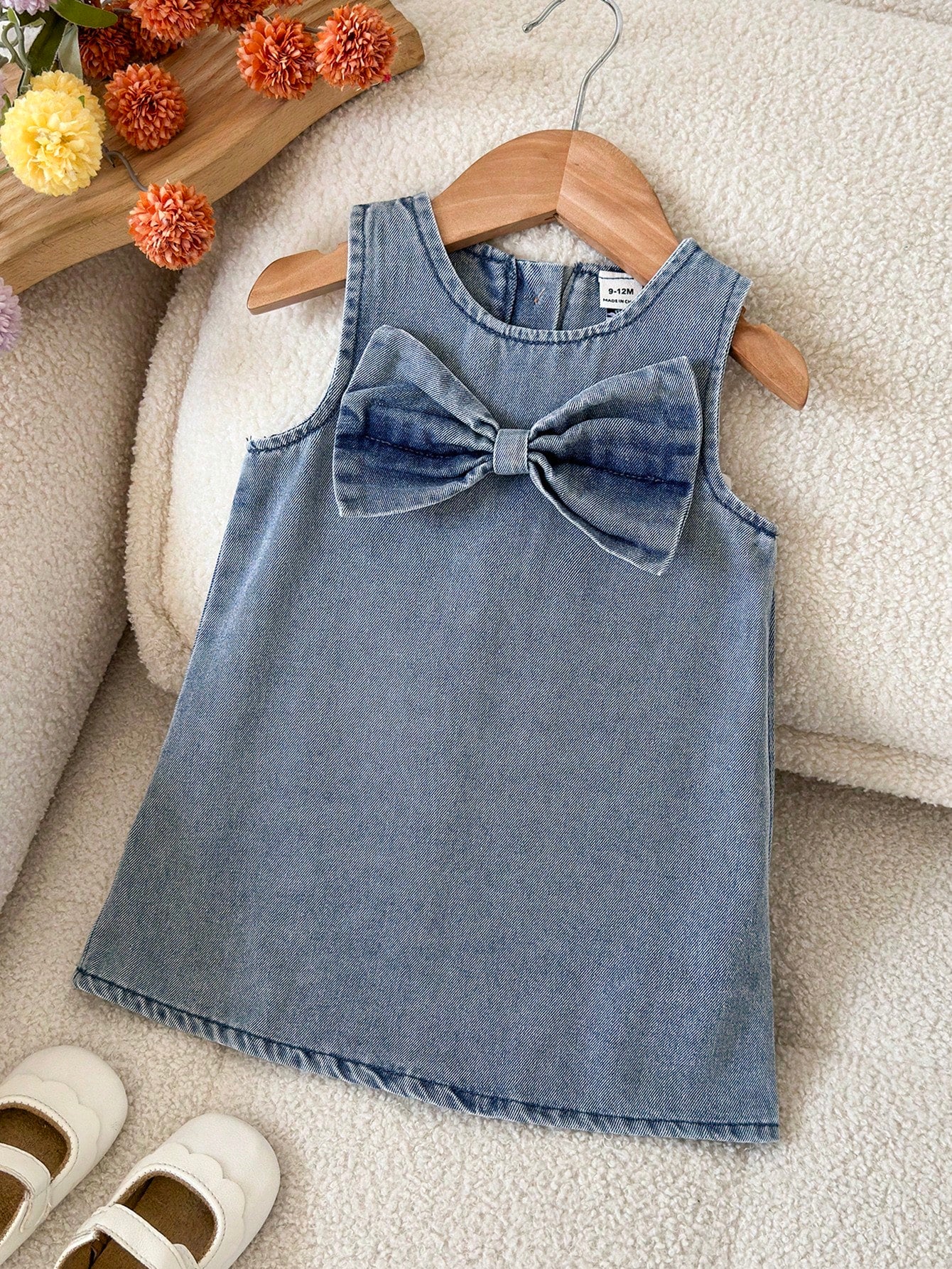 Prenda azul vestido de mezclilla para bebe con lazo frontal vista frontal
