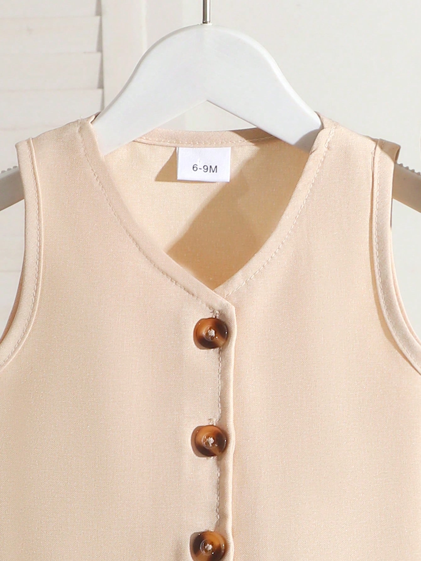 Prenda albaricoque chaleco para bebe con cuello en V y botones delanteros