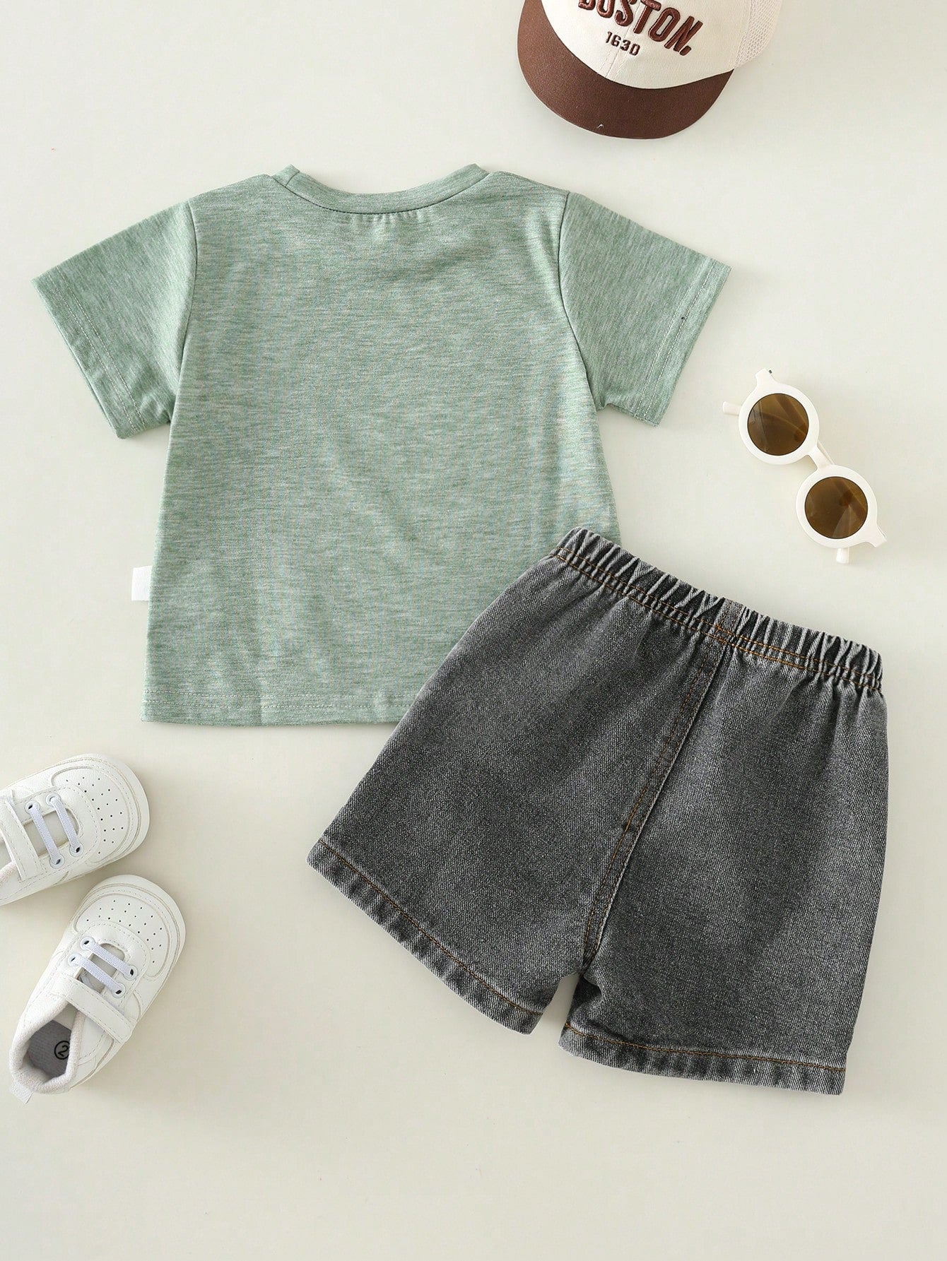 Prenda verde conjunto para bebe con camiseta estampada y shorts negros vista trasera
