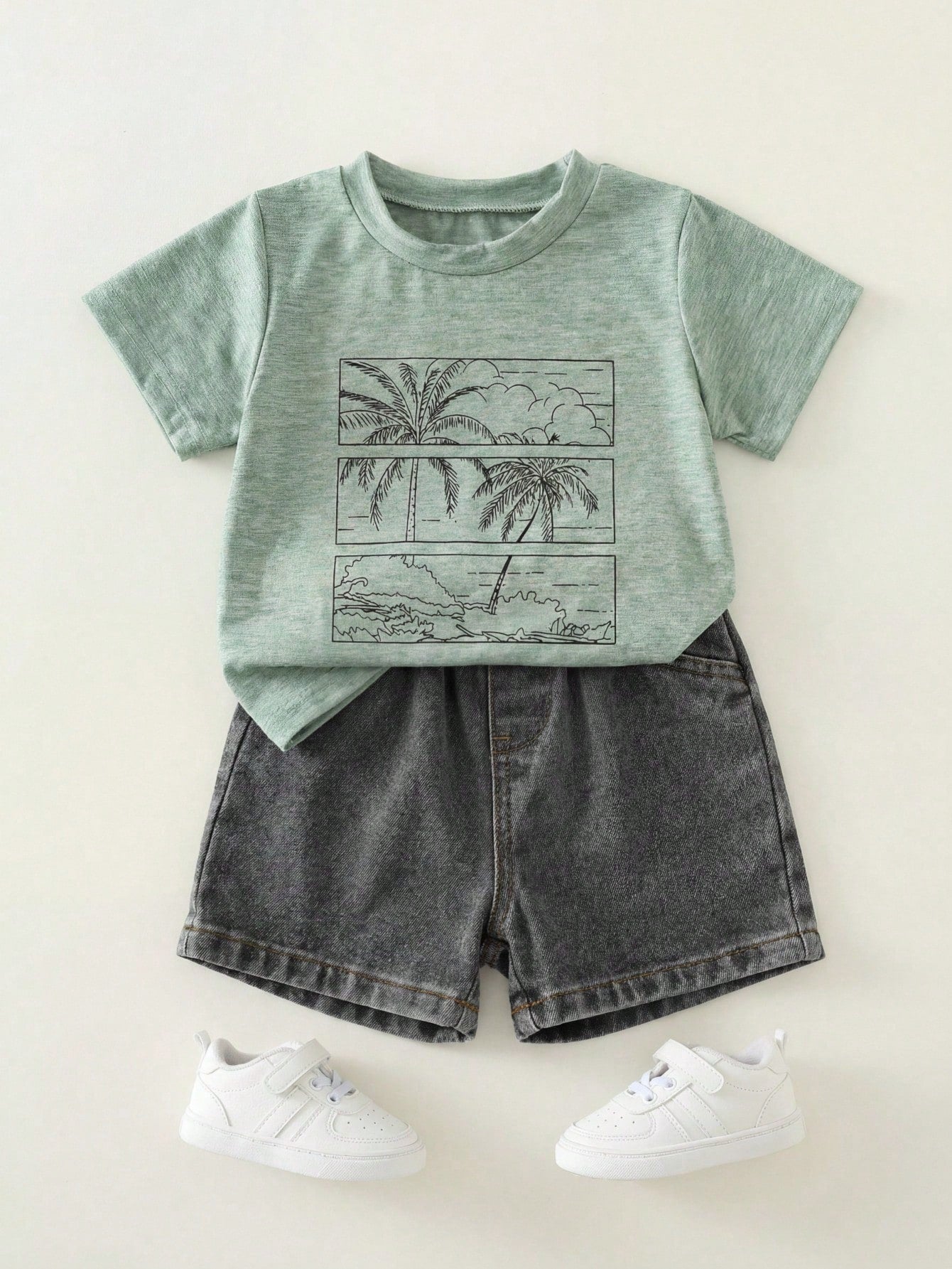 Prenda verde conjunto para bebe con camiseta estampada y shorts negros vista frontal