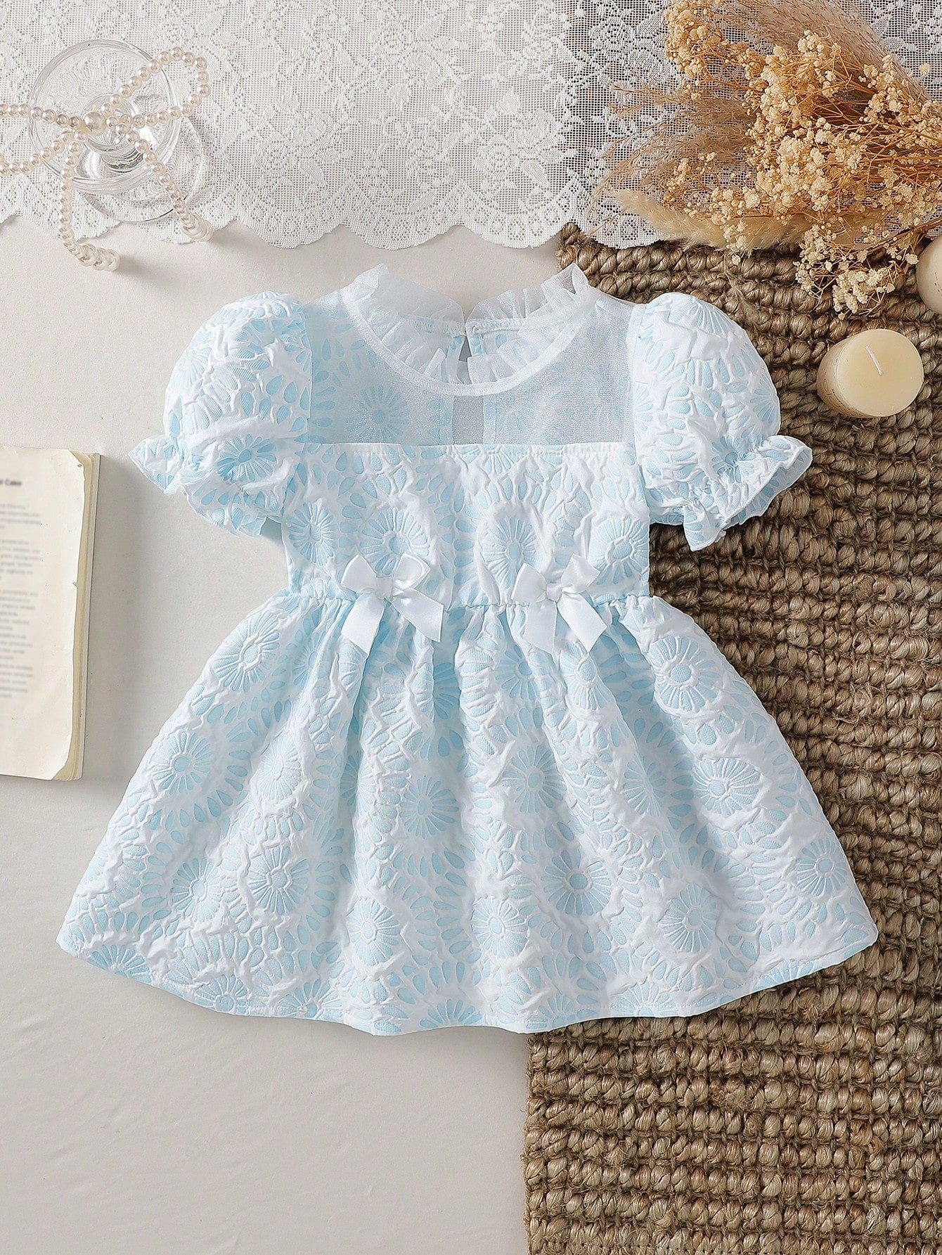 Prenda celeste vestido para bebe con bordado floral y lazos vista frontal