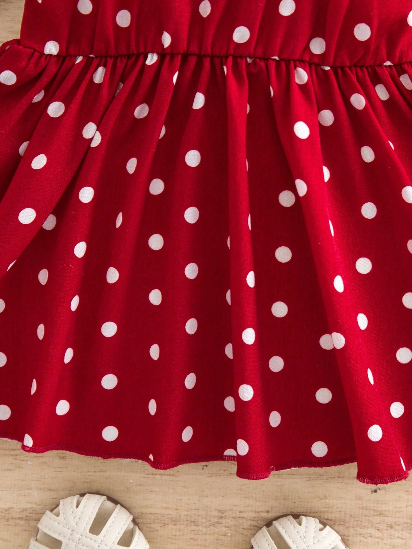 Prenda roja vestido para bebe detalle de tela con lunares
