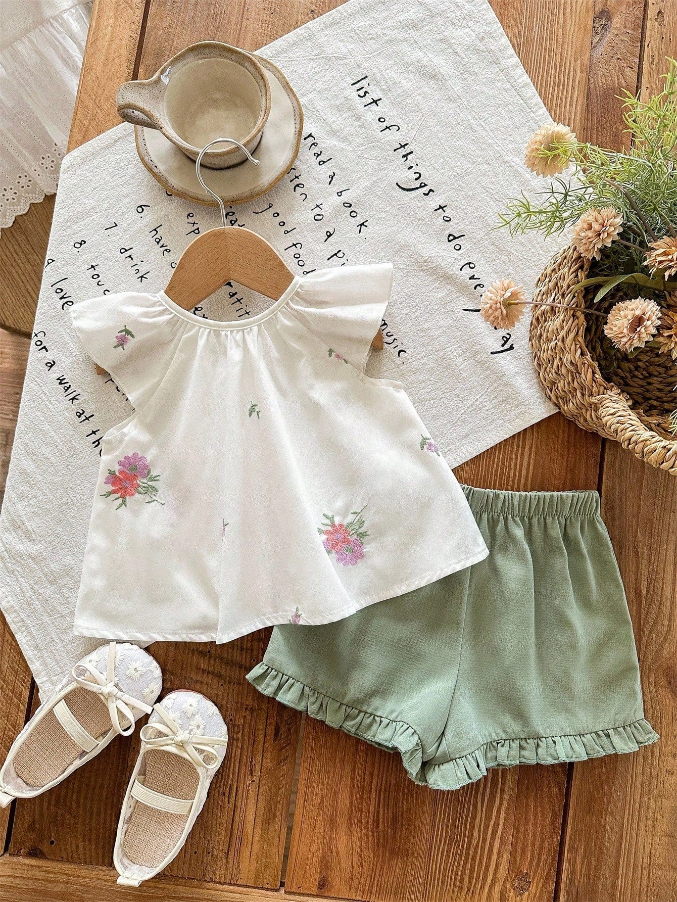 Prenda blanca conjunto para bebe con bordado floral y short verde vista trasera