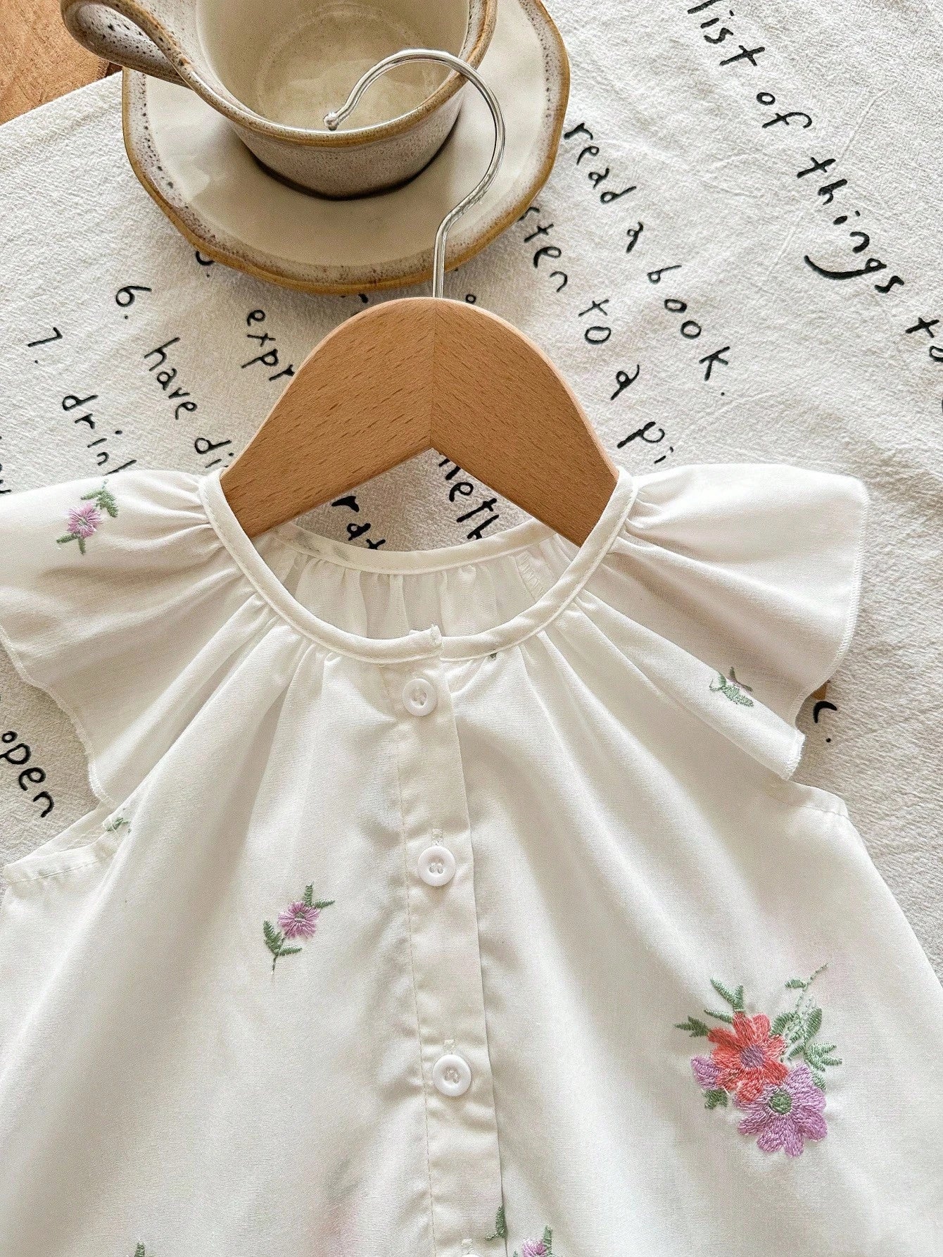 Prenda blanca conjunto para bebe detalle de bordado floral y botones delanteros