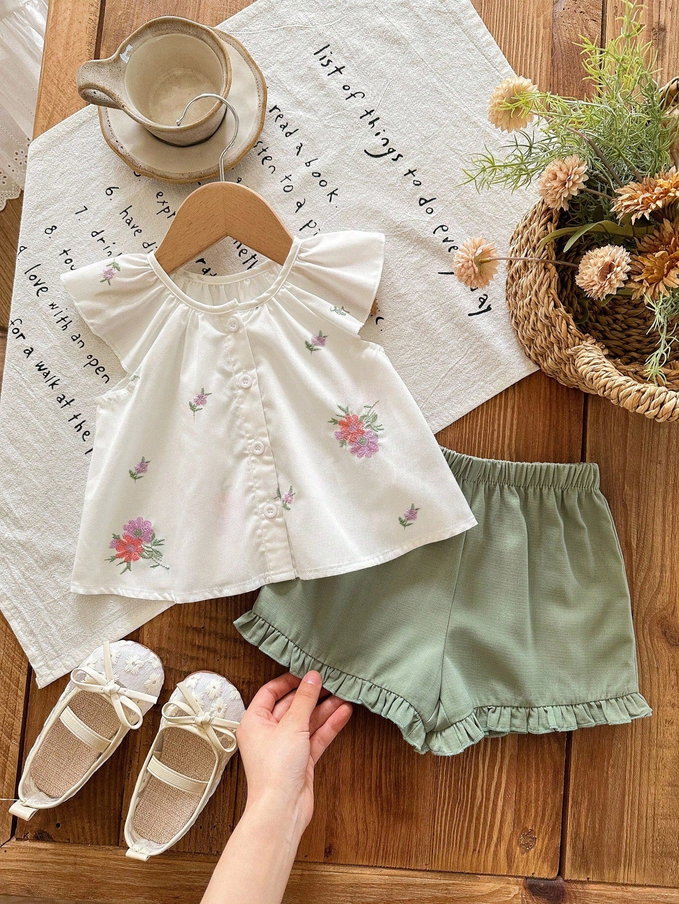 Prenda blanca conjunto para bebe con bordado floral y short verde vista frontal