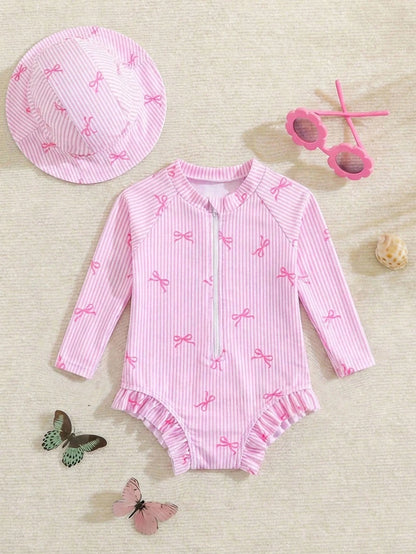 Prenda rosa traje de baño para bebe con rayas y lazos vista frontal con gorro