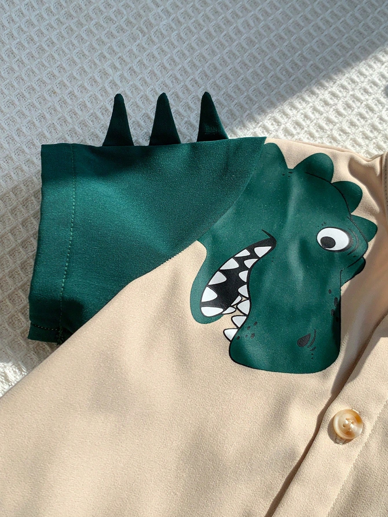 Prenda beige conjunto para bebe con detalle de estampado dinosaurio en manga
