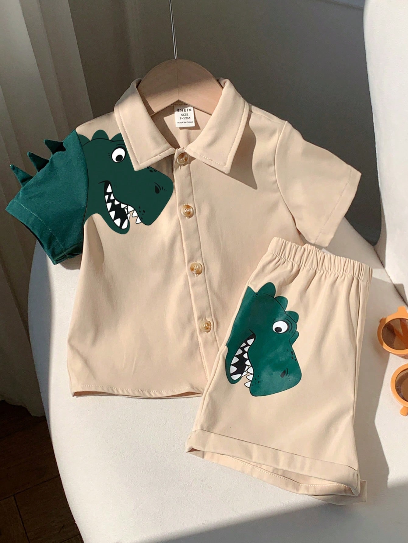 Prenda beige conjunto para bebe con dinosaurio verde y short vista frontal