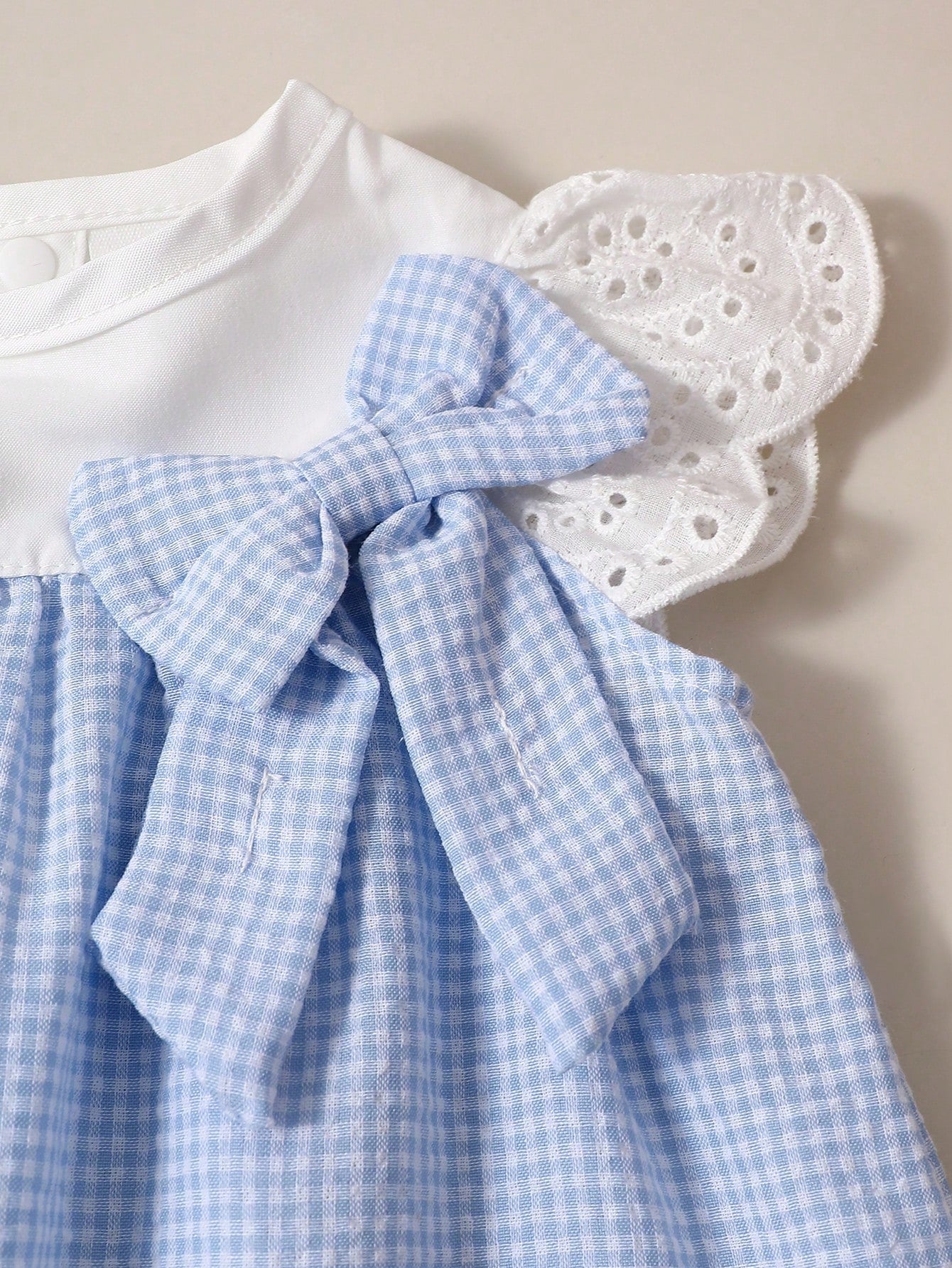 Prenda azul vestido para bebe con lazo decorativo detalle del acabado