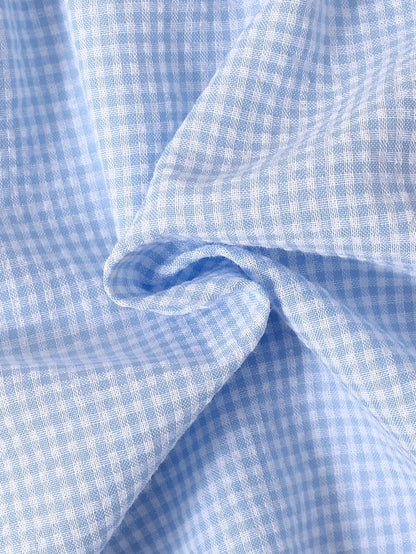 Prenda azul vestido para bebe con tela a cuadros detalle del tejido