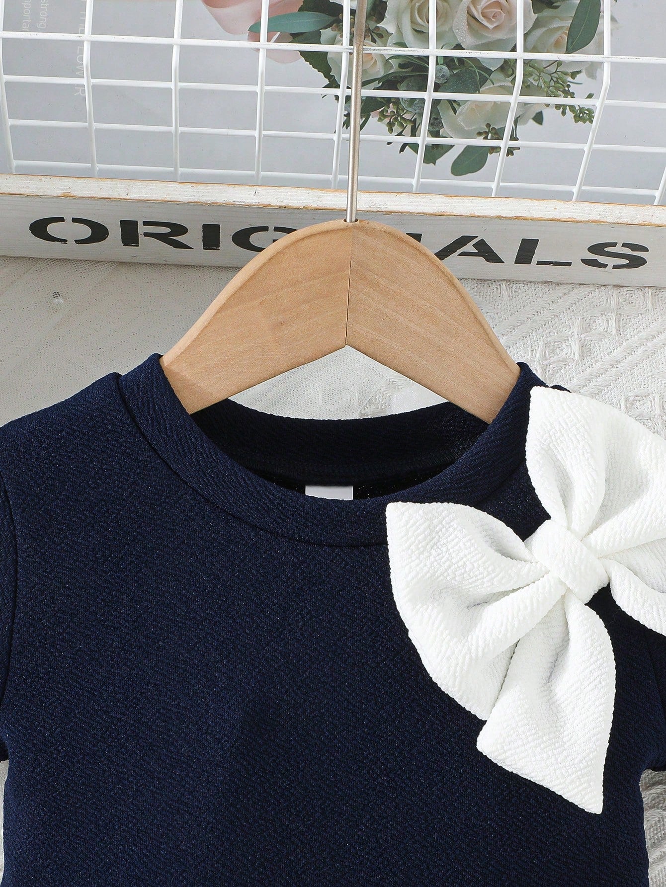 Prenda azul marino vestido para bebe detalle de lazo blanco
