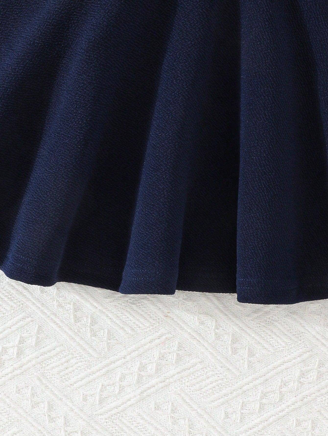 Prenda azul marino vestido para bebe detalle de falda acampanada