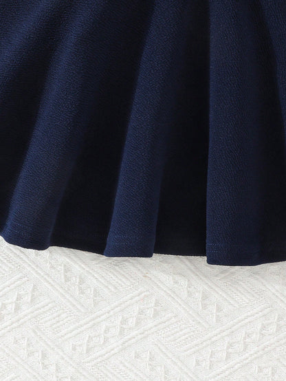 Prenda azul marino vestido para bebe detalle de falda acampanada