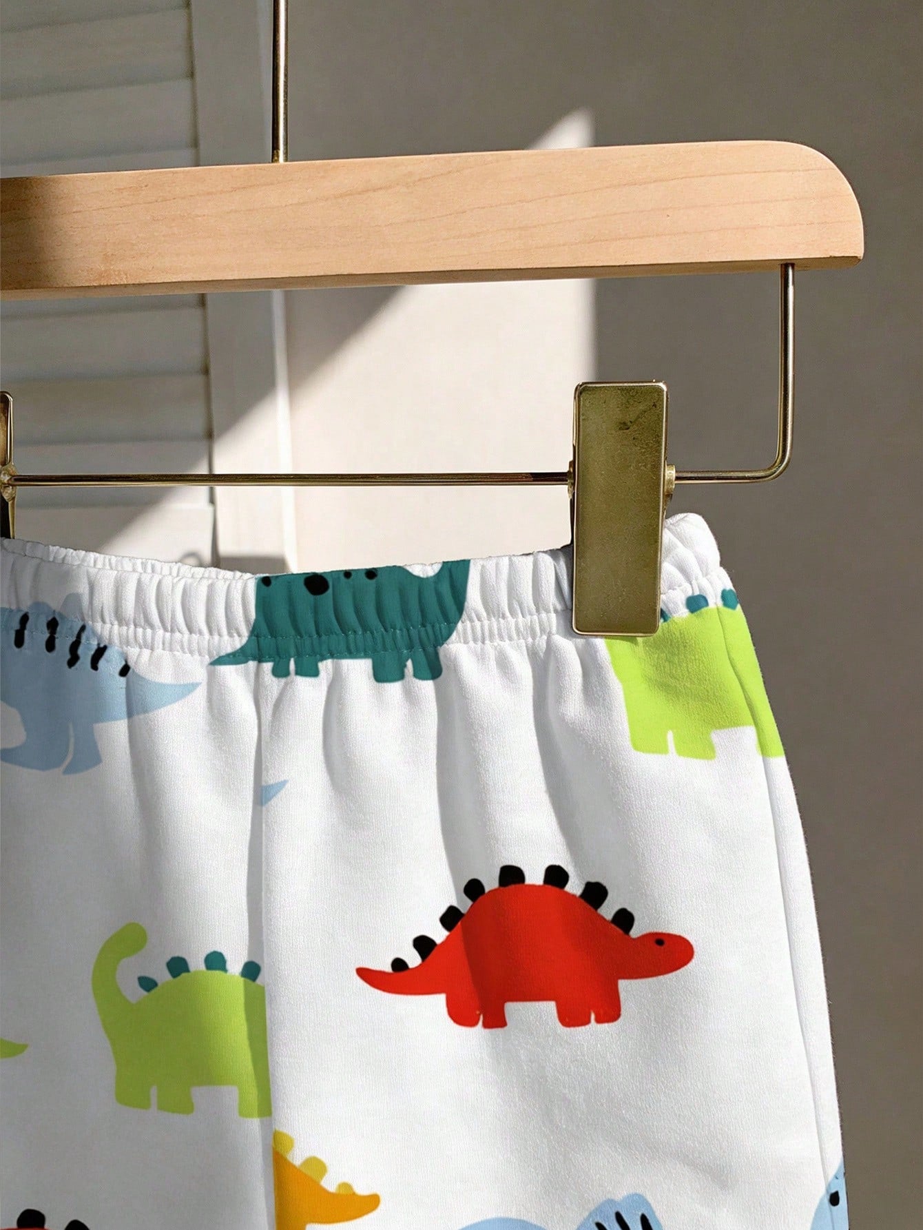 Prenda blanca conjunto para bebe con detalle de short elástico y estampado de dinosaurios