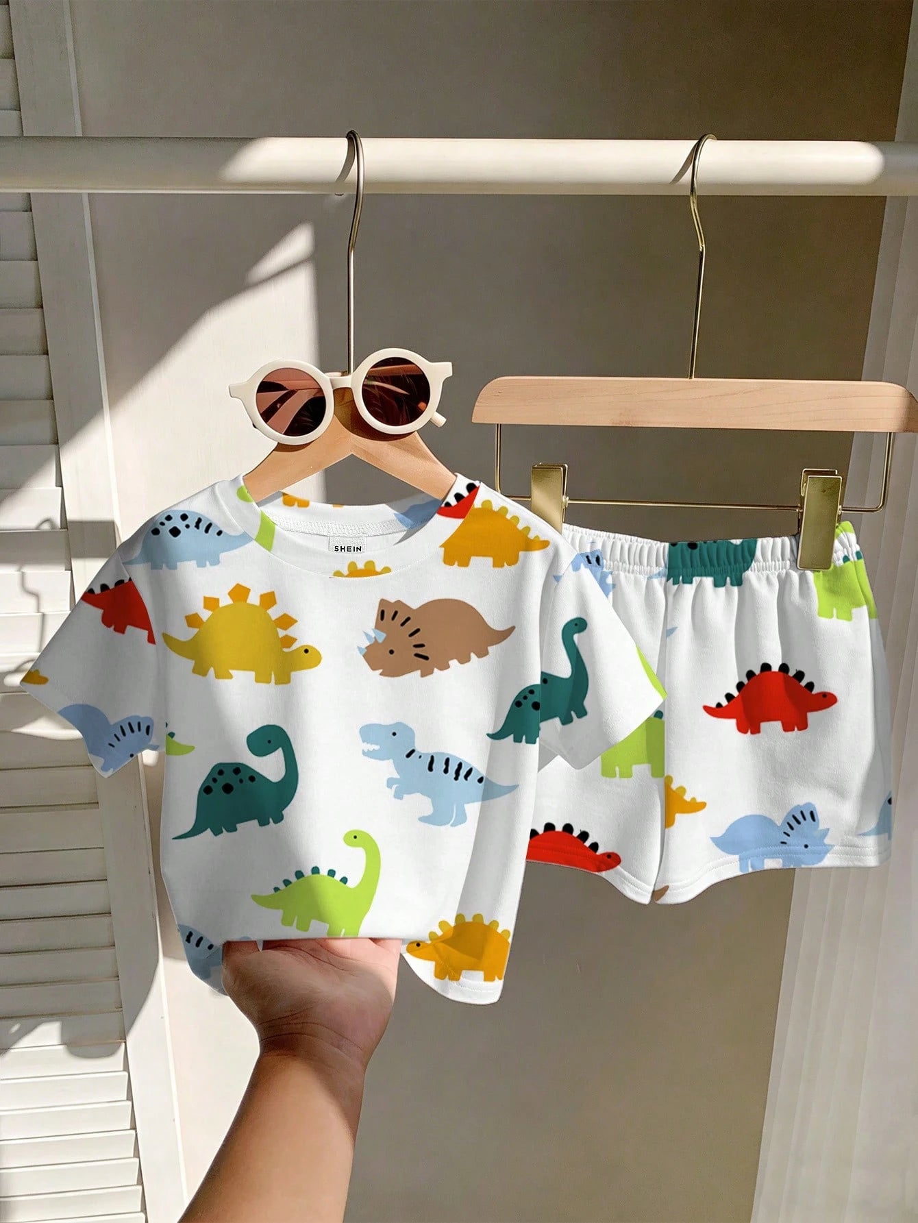 Prenda blanca conjunto para bebe con dinosaurios coloridos vista frontal