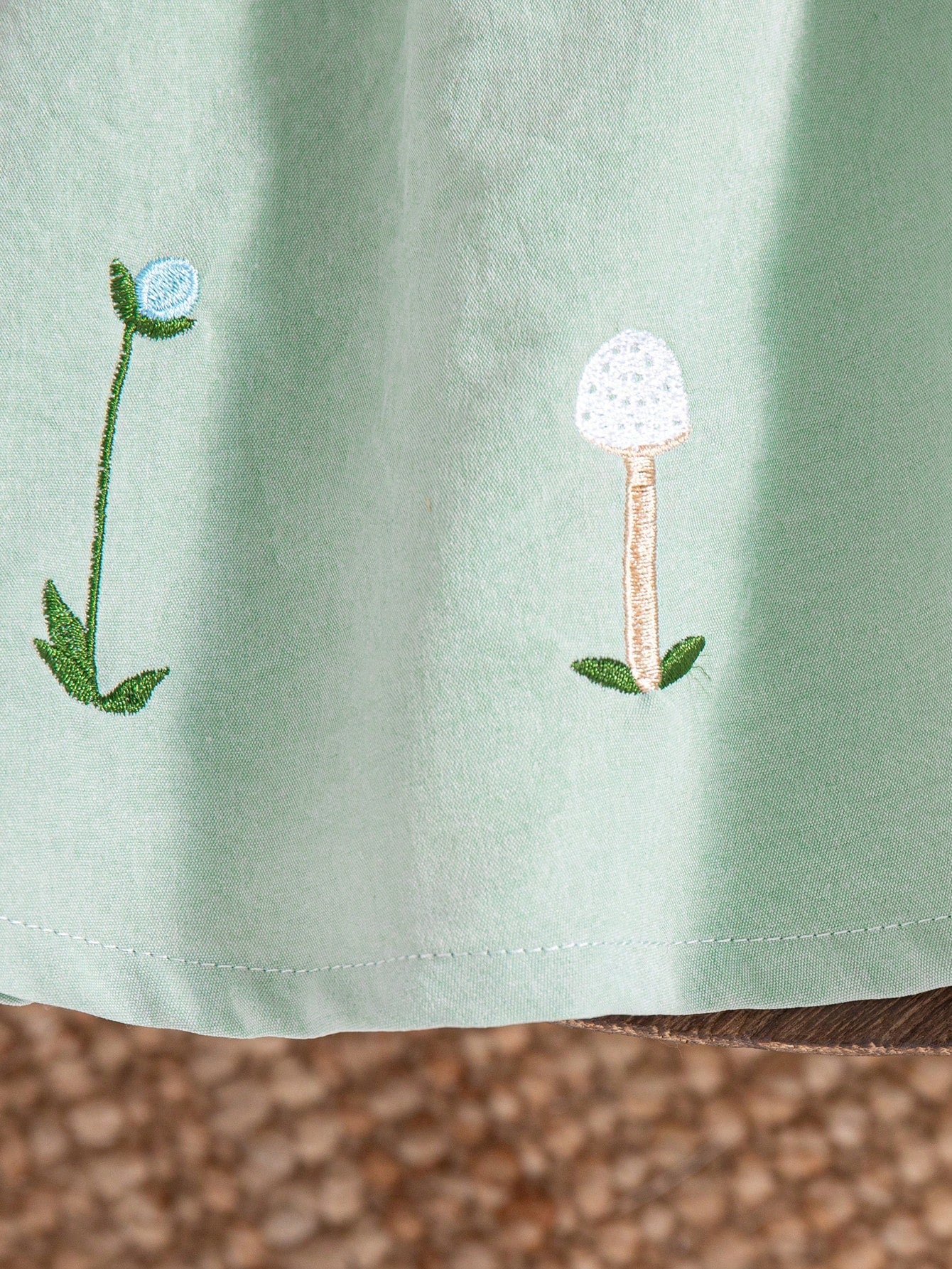 Prenda verde vestido para bebe detalle de bordado floral
