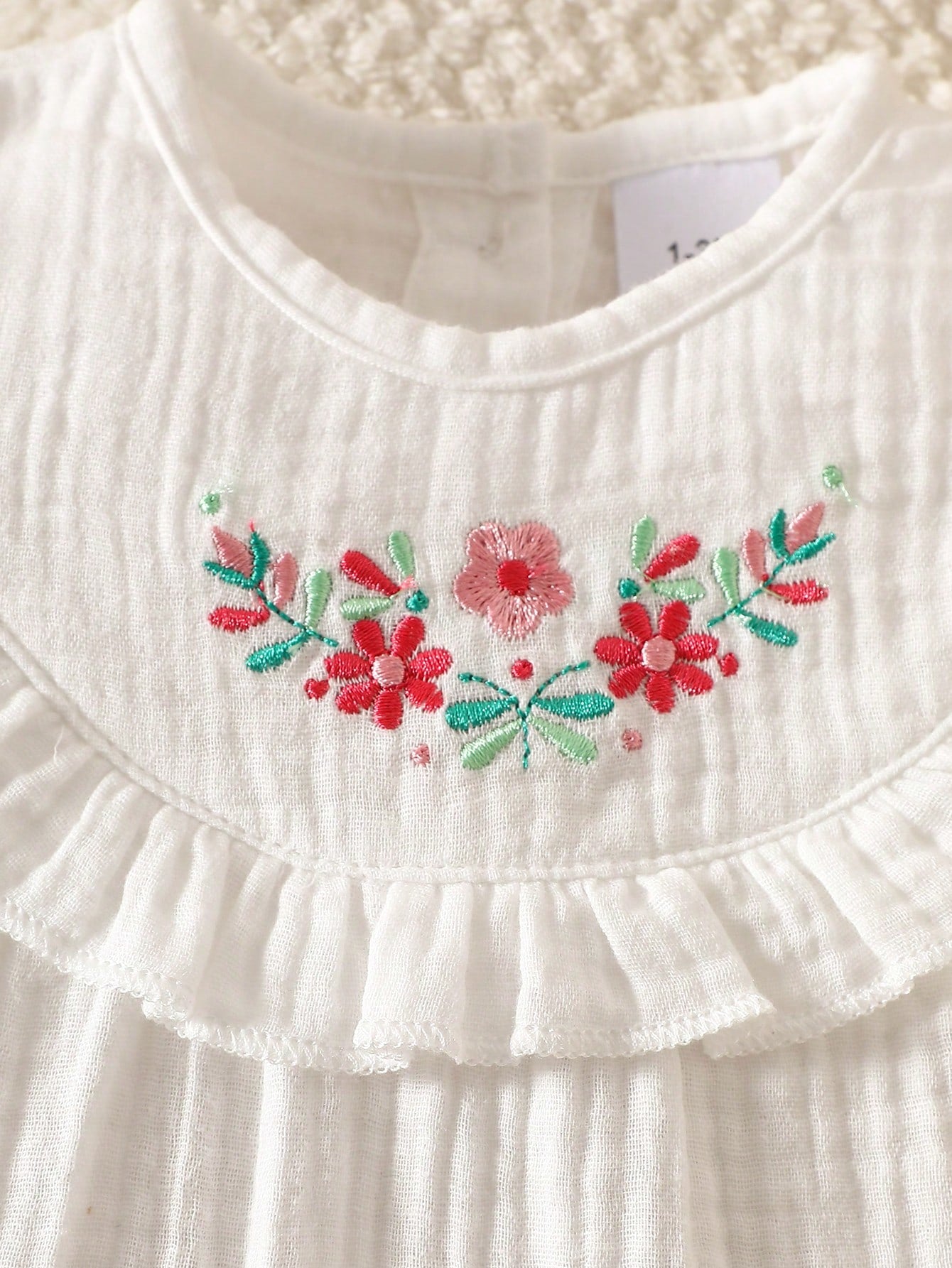 Prenda blanca vestido para bebe detalle de bordado floral