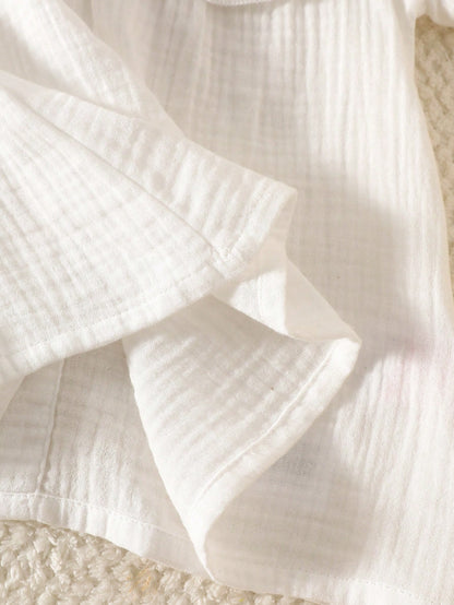 Prenda blanca vestido para bebe detalle del acabado de la tela
