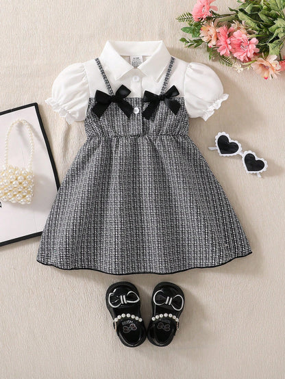 Prenda blanco y negro vestido para bebe vista frontal con lazos negros