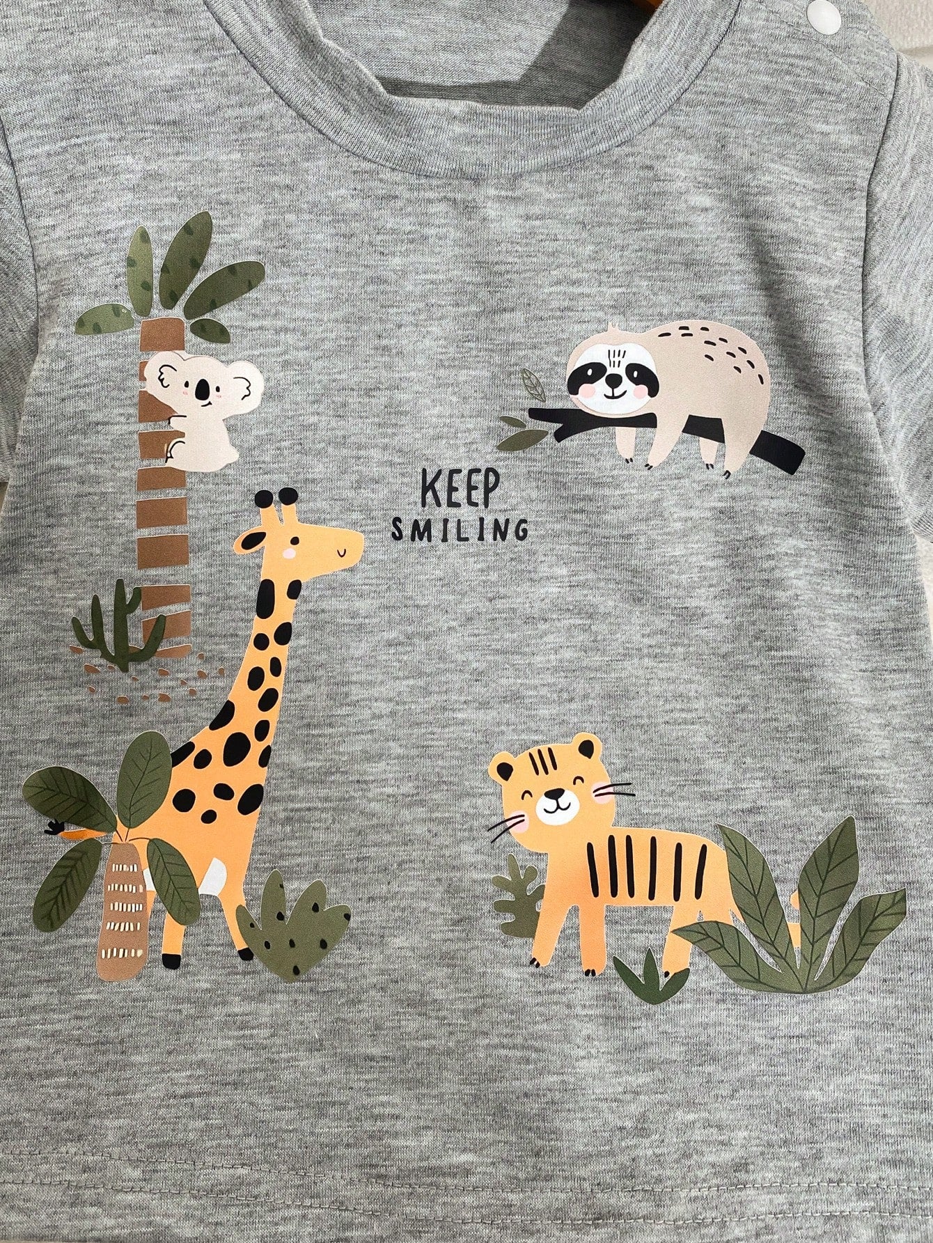 Prenda gris camiseta para bebe detalle de estampado de animalitos