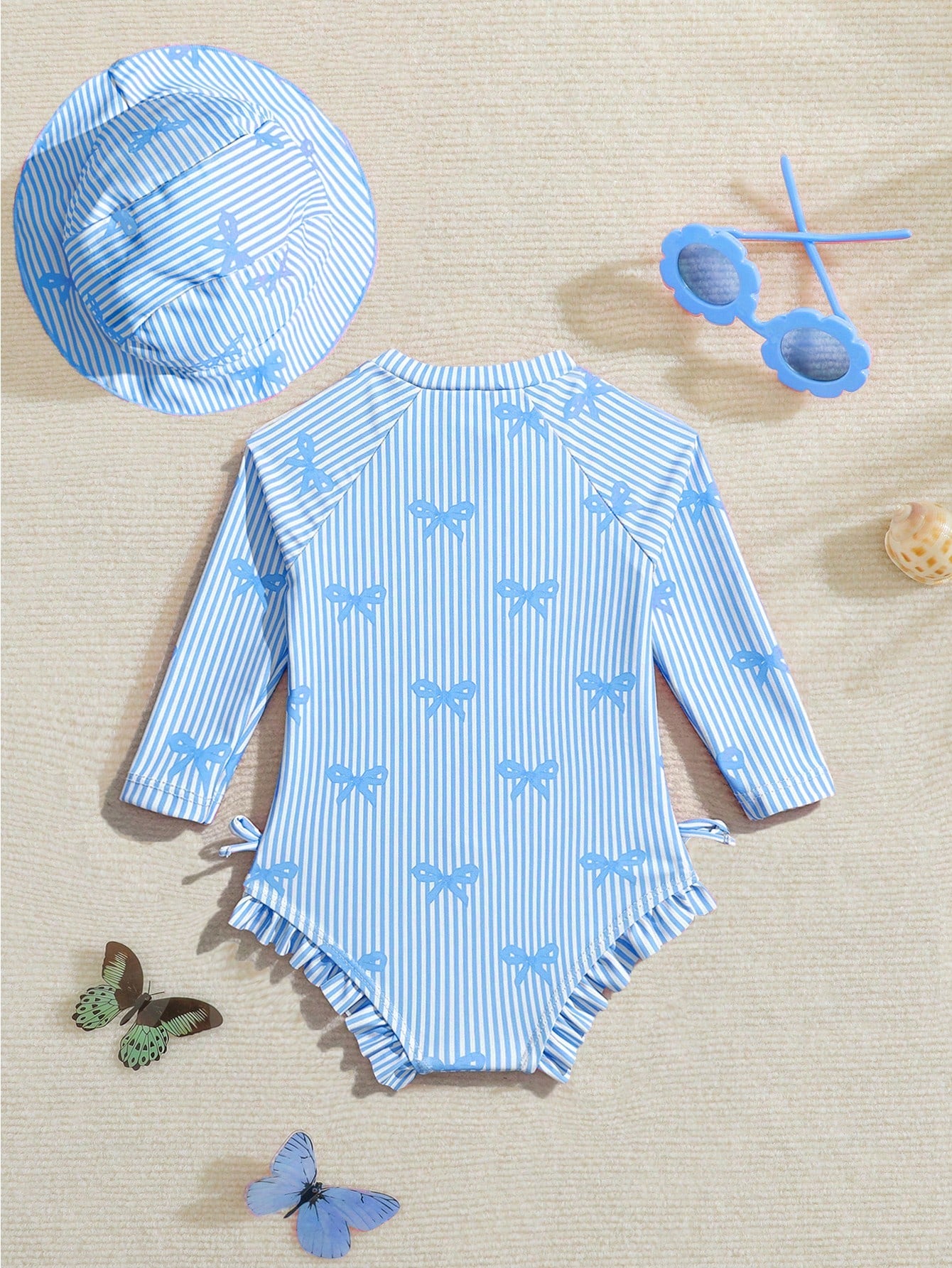 Prenda azul traje de baño para bebe con moños y gorro vista posterior