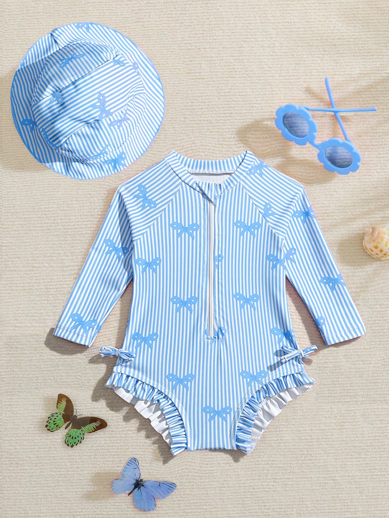 Prenda azul traje de baño para bebe con moños y gorro vista frontal