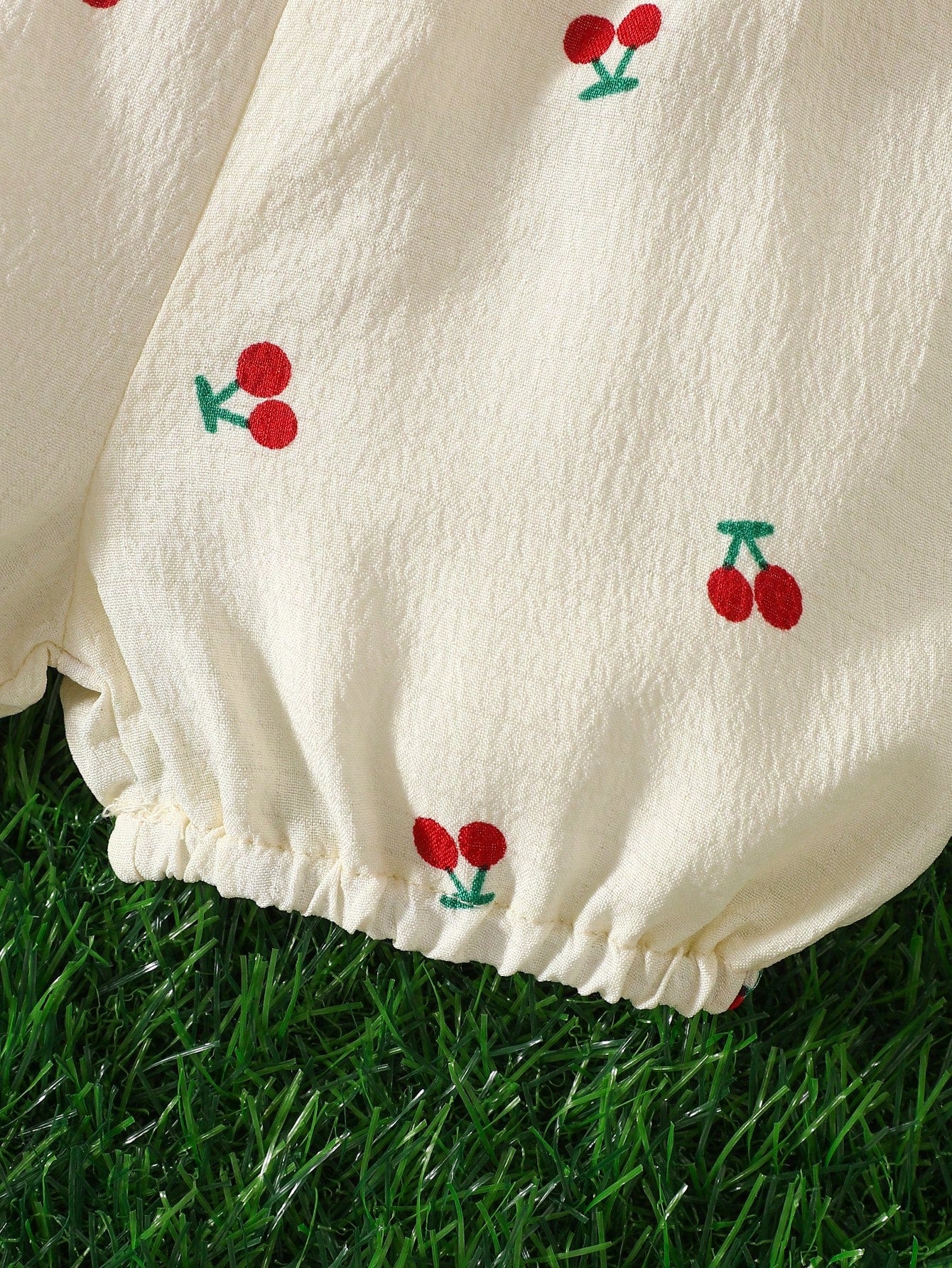 Prenda albaricoque short para bebe detalle de estampado de cerezas