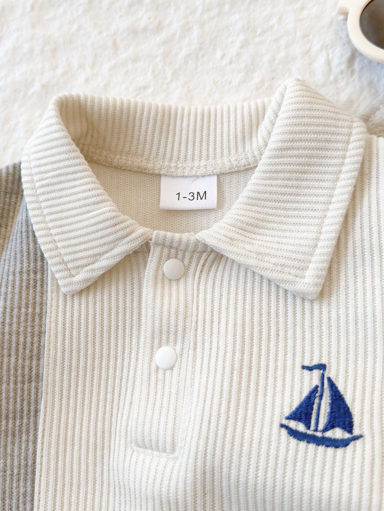 Prenda blanca pelele para bebe detalle de cuello polo y barco bordado