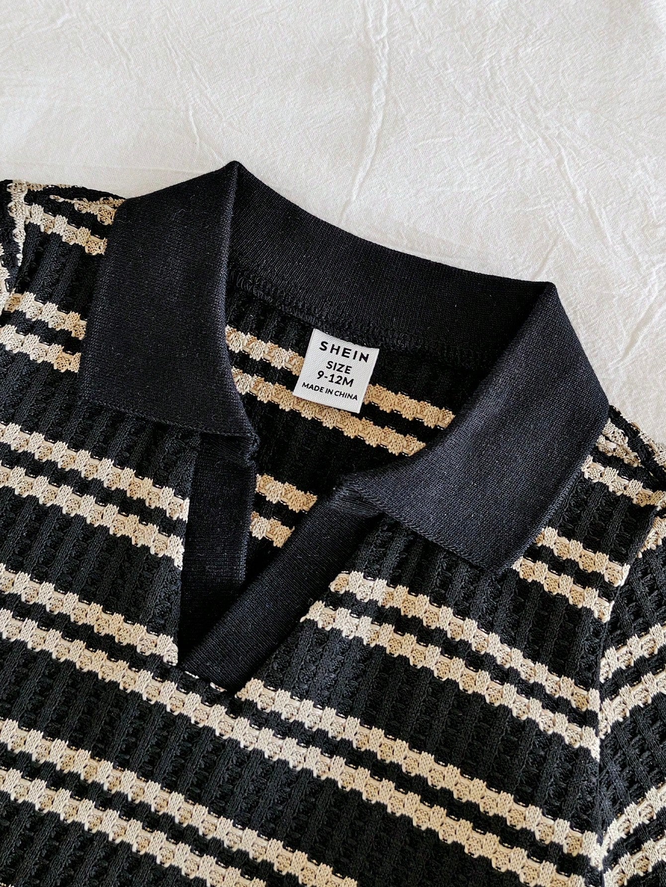 Prenda negra conjunto para bebe detalle de cuello tipo polo y rayas
